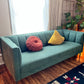 This is a forest green retro mcm style sofa with over stuffed backing.