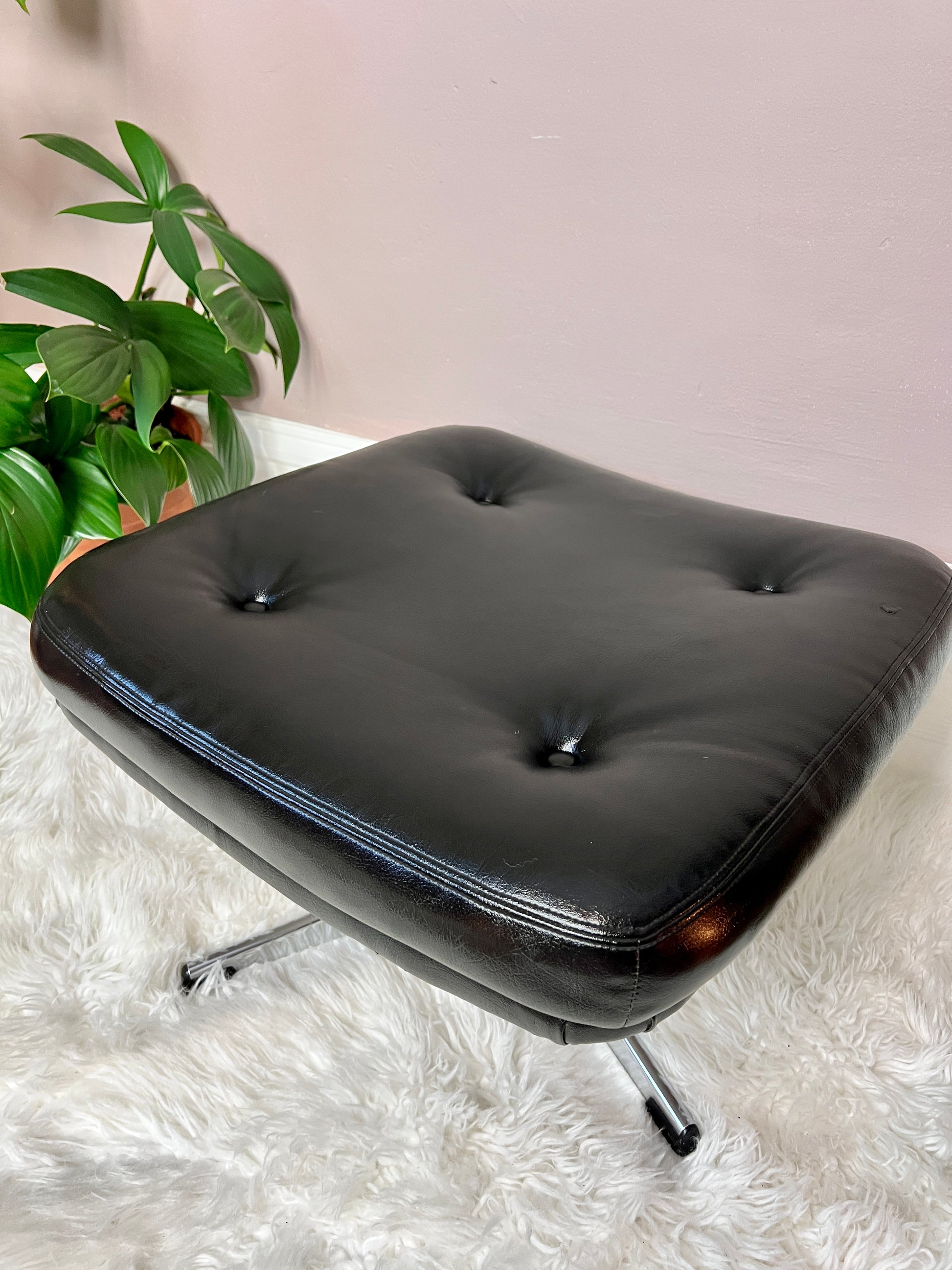 This is a black vinyl & chrome eames style ottoman footstool